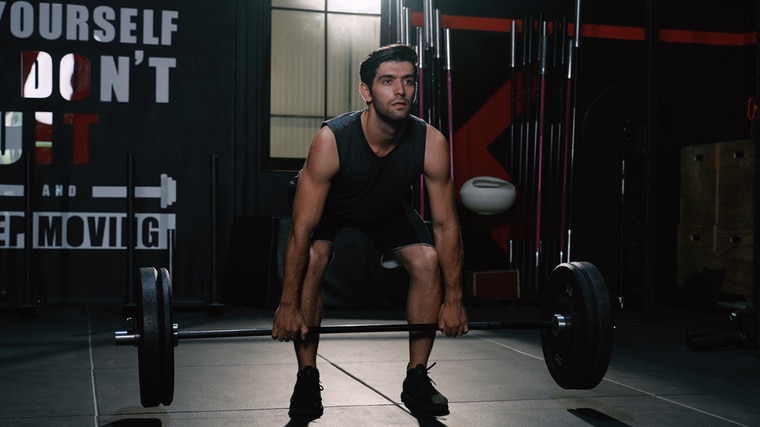 Man in gym performing barbell exercise